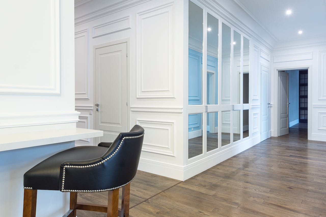 contact-img Spacious contemporary interior features white panel walls, mirrored doors, and elegant wooden flooring.